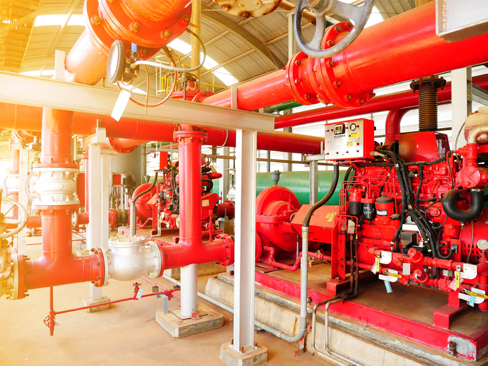 fire protection system in Sydney showing vrious red pipes, diesel motor, vlves, pumps, gauges, and fire protection systems equipment