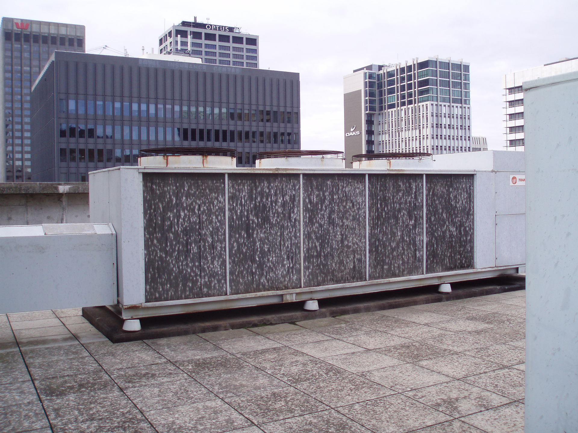 Chiller Monitoring & Control for Unsupervised Buildings - air-cooled scroll chiller with condenser coils damaged by recent hail on the roof of a Melbourne Commercial Property Building