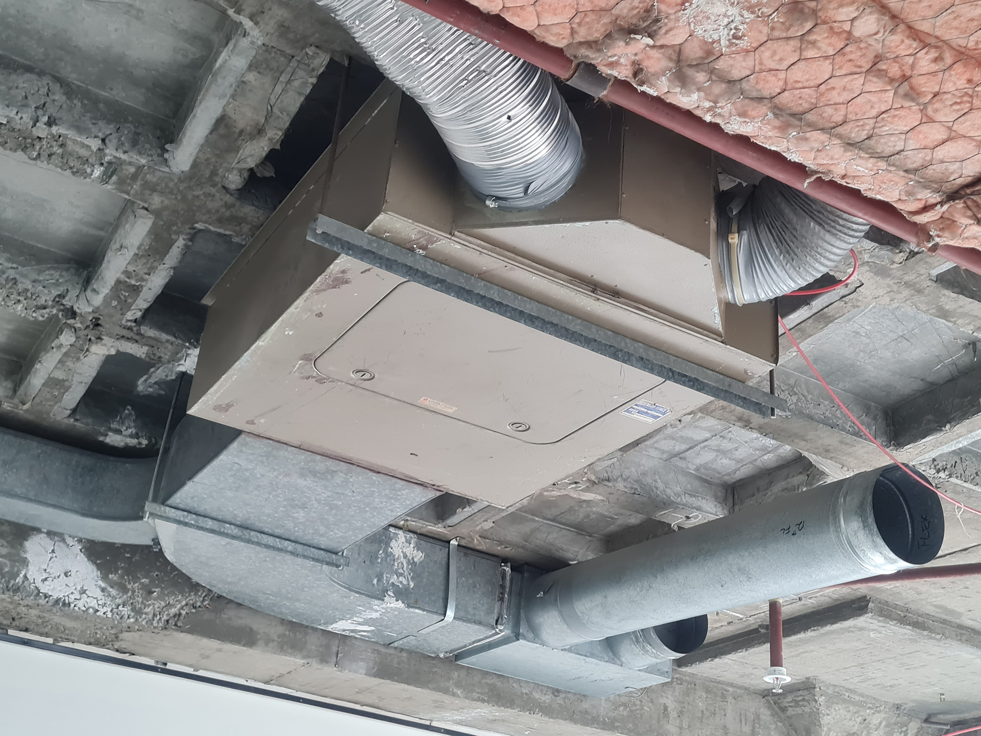 In many HVAC systems installed during the 1960s and early 1970s, conditioned air was often controlled through a mixing box arrangement. Hot air entered the box from one side and cool air from the other, with an internal damper modulating between the two air streams. The damper was commonly controlled by a pneumatic signal from a wall-mounted room thermostat or sensor, allowing the box to deliver warmer or cooler air depending on space temperature demand. While this was a practical control method at the time, it was not particularly energy efficient. These systems often involved simultaneous heating and cooling, higher fan energy, constant air volumes, pneumatic control drift, air leakage, and ongoing maintenance of dampers, actuators, sensors and tubing. Over time, these older dual-duct and mixing box systems were progressively replaced by more efficient primary air systems using Variable Air Volume boxes. VAV systems allowed airflow to be reduced when demand was lower, improving energy performance, comfort control and maintainability across commercial buildings.