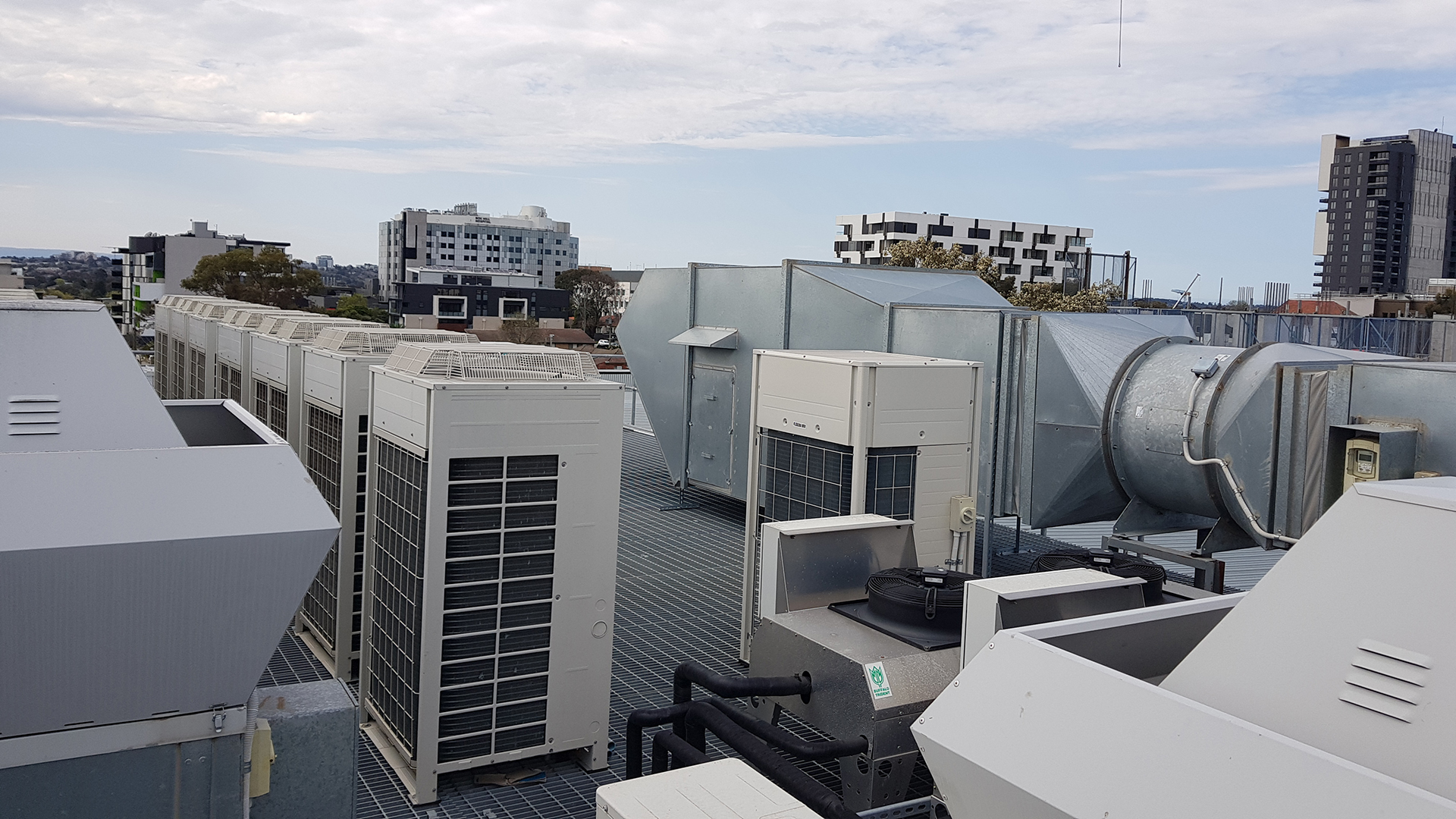 roof top in Melbourne with the VRV condenser units and the various Exhaust fnas nd stir pressurisation fans serving the apartment block below and the retail ground floor.