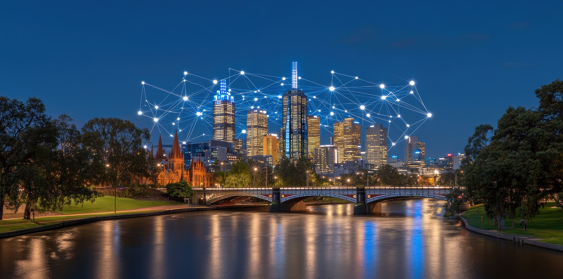 Melbourne skyline along the Yarra River at night with illuminated skyscrapers connected by glowing digital network lines, representing smart buildings, building management systems (BMS), automation, energy management, and commercial property technology.