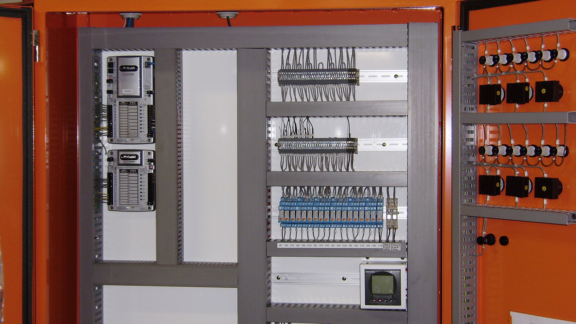 New Mechanical Services Switchboard (MSSB) with BACnet Building Management System controllers, safety relays, terminal strips, control switches, communication modules and automation components mounted within an orange industrial enclosure, supporting HVAC plant and critical building services. - Collins Street Building, Melbourne