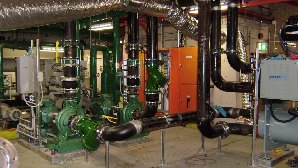 Modern commercial building plant room featuring new chilled water pumps, condenser water pumps, high-efficiency smart chiller, mechanical services switchboard, electrical infrastructure, BMS controls and automation systems in a recently upgraded facility in Melbourne and Sydney.