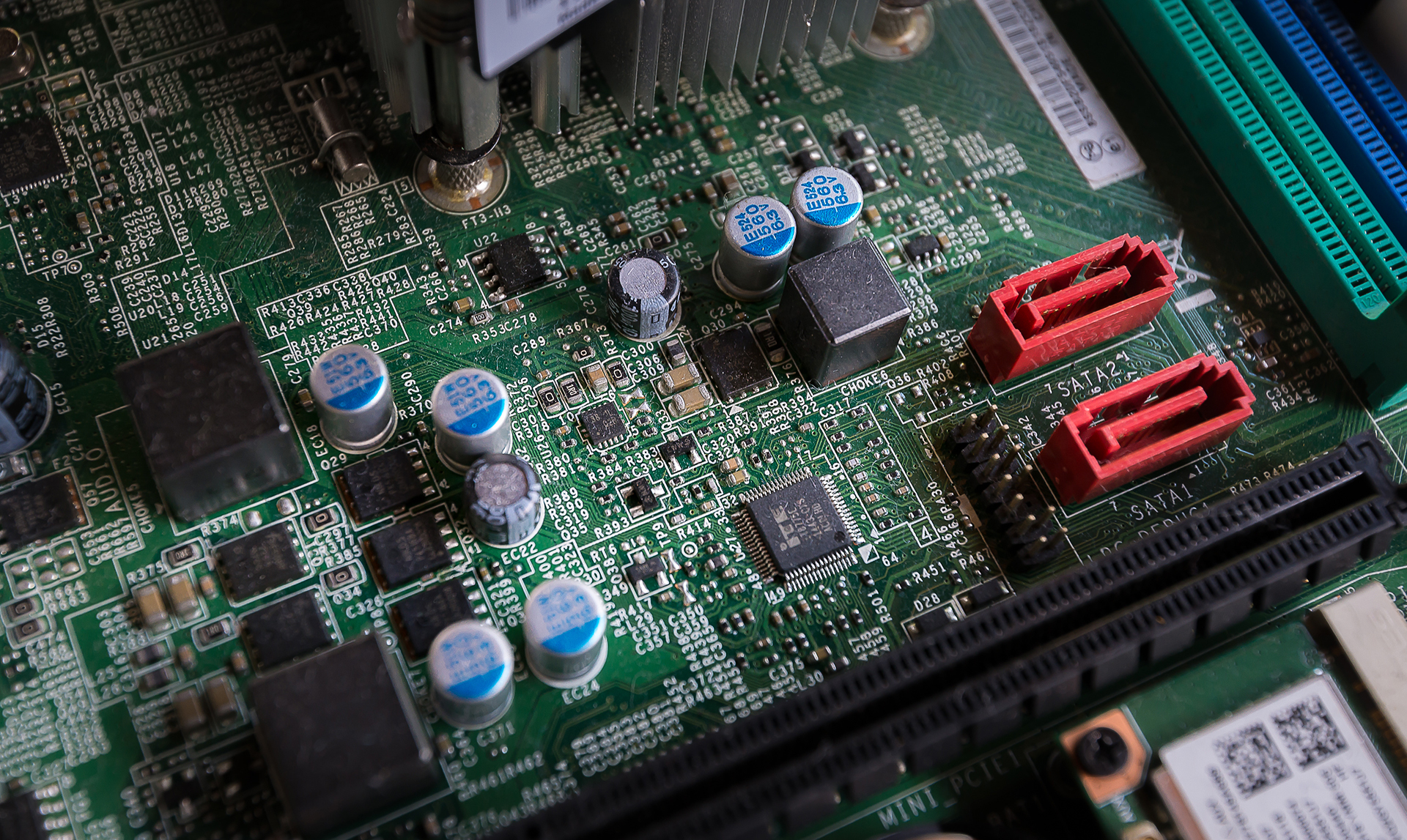 Close-up of an electronic controller circuit board representing the hardware at the heart of a commercial Building Management System used to control HVAC and building services.