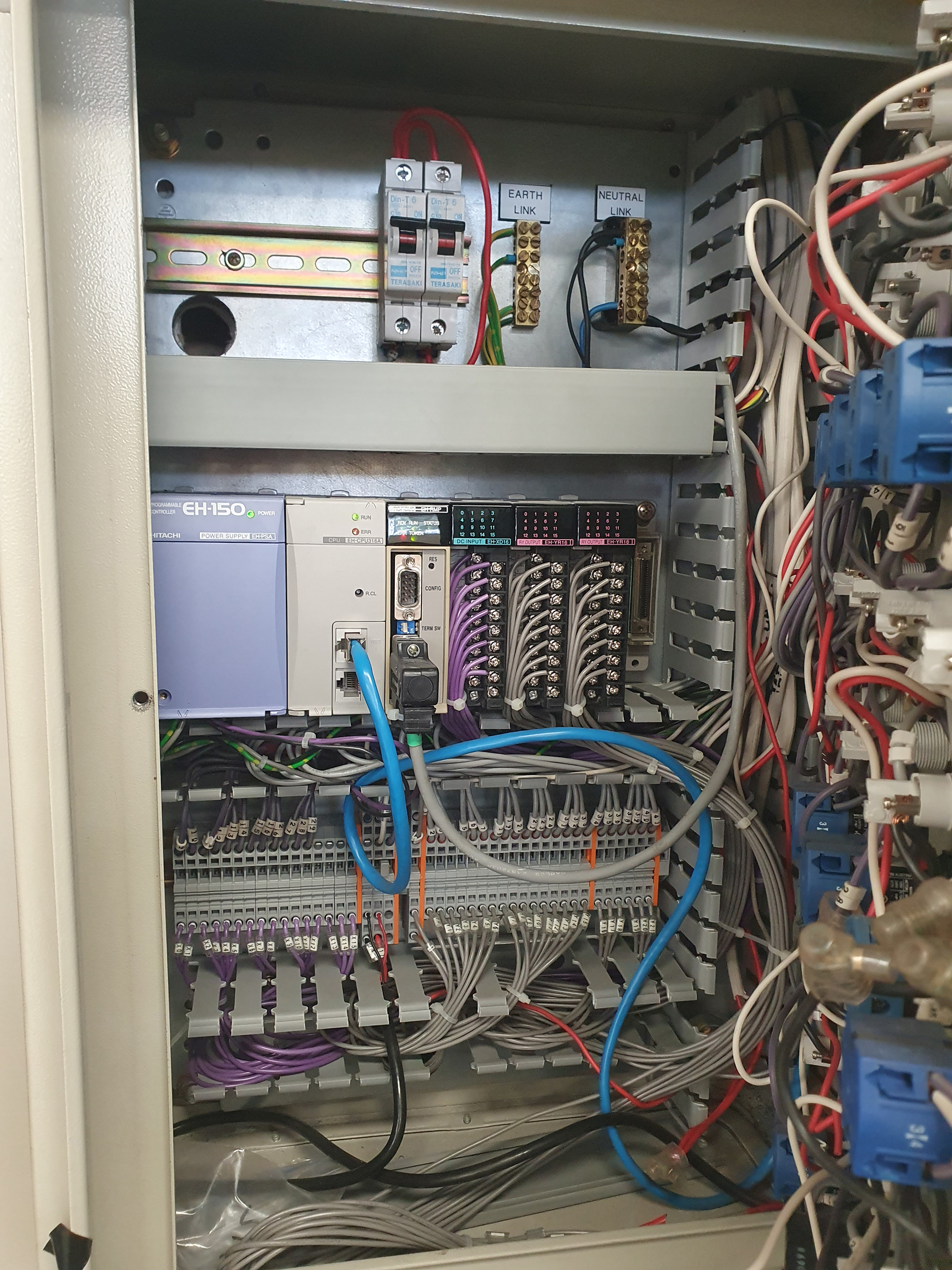 Central PLC control panel for a commercial basement car park carbon monoxide ventilation system showing controller, communications modules, terminal strips and field wiring.