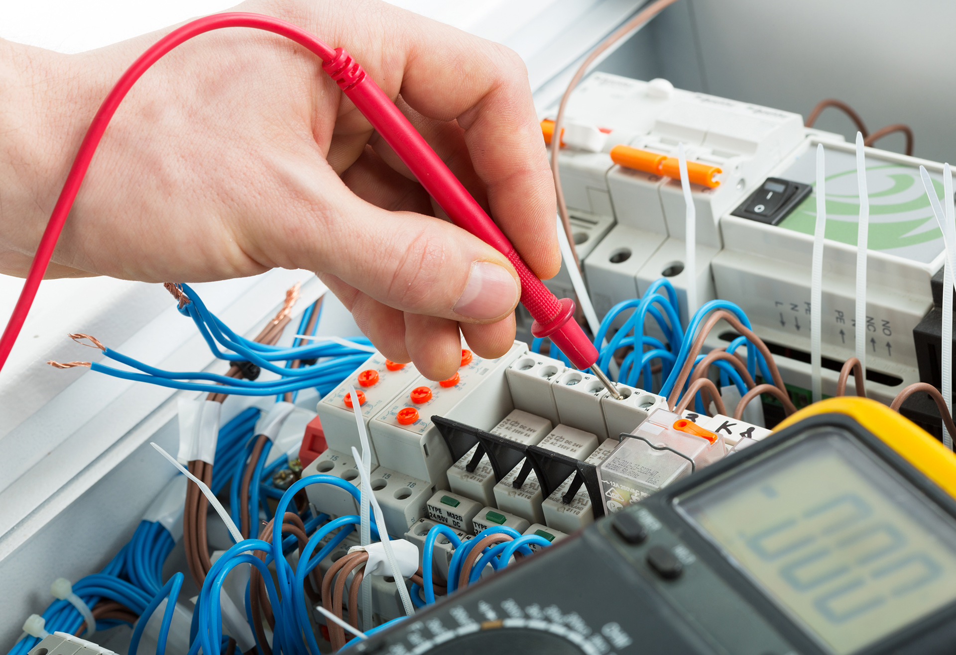 WR8Technican working with a multi-meter investagating control problem in a switchboiard gear panel