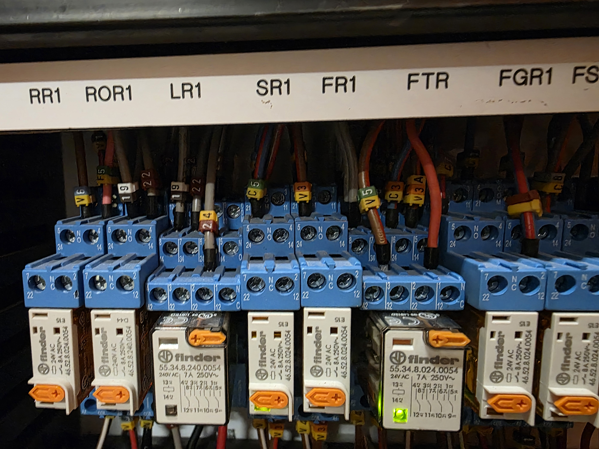 Close-up of Finder interface relays inside a commercial Mechanical Services Switchboard showing labelled control relays including the Fire Trip Active (FTA) relay used to interface the fire system with HVAC mechanical services.