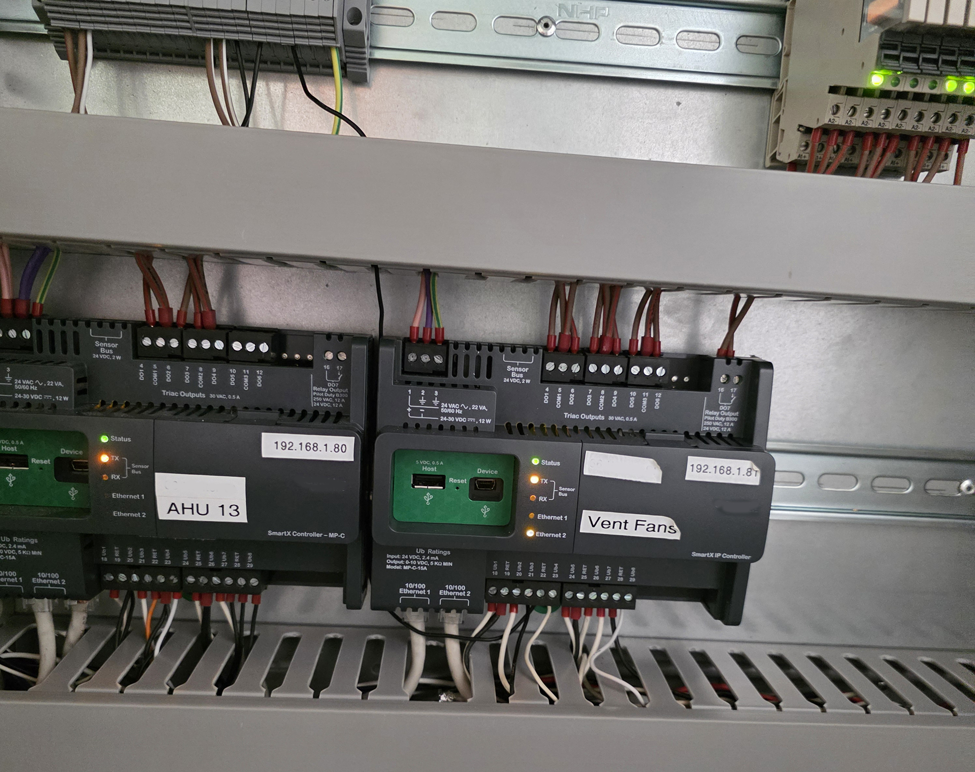 Schneider Electric SmartX IP Building Management System controllers controlling air handling units and variable speed ventilation fans in a commercial building.