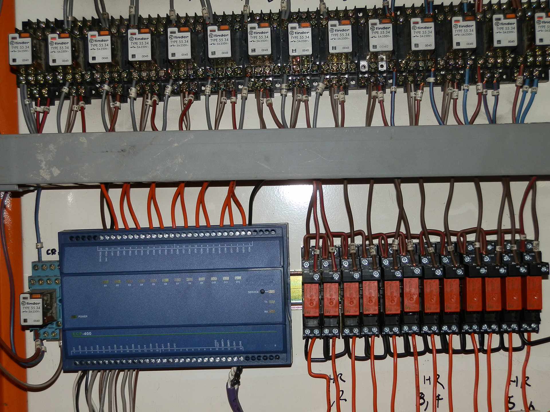 Older Distech ECP-400 Lon controller connected to banks of ageing control relays inside a mechanical services switchboard in Melbourne.