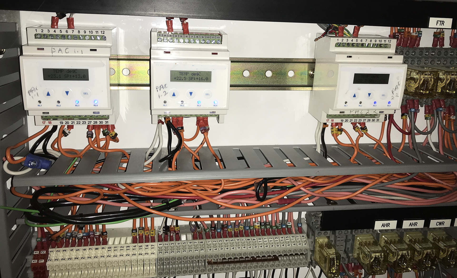 Legacy Regulator controllers serving packaged air-conditioning units inspected during BMS recommissioning in a commercial building.