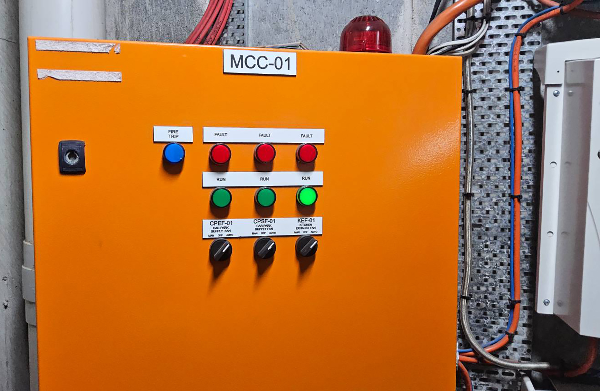 Mechanical services switchboard front panel with indicator lamps showing run and fault status for fans and other mechanical plant.